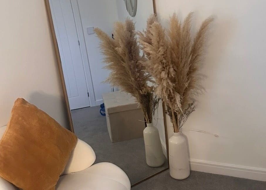 Elegant decor at Caimem Hair, Swadlincote, England, GB featuring a chair, mirror, and pampas grass in vases.