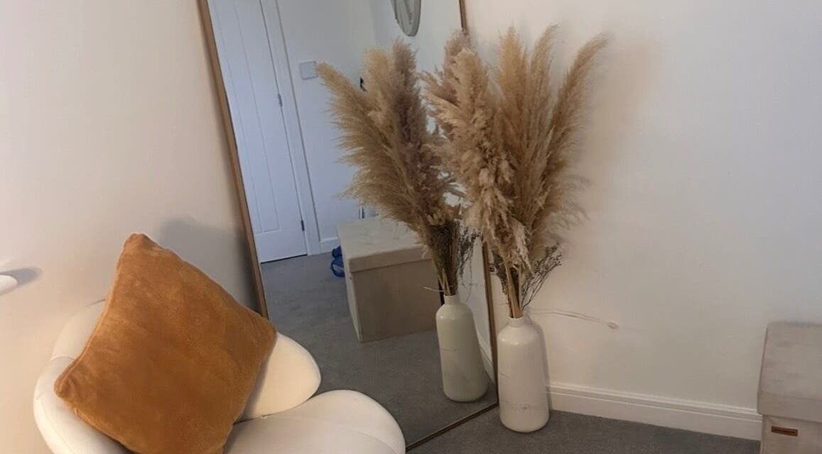 Elegant decor at Caimem Hair, Swadlincote, England, GB featuring a chair, mirror, and pampas grass in vases.