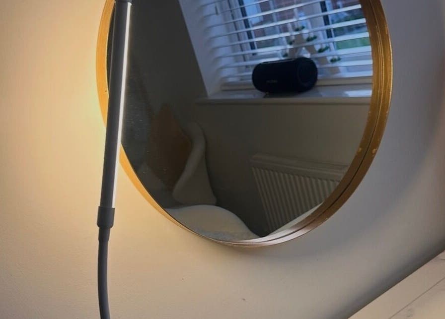 Stylish round mirror with gold rim at Caimem Hair, Swadlincote, England, GB enhancing chic interior design.