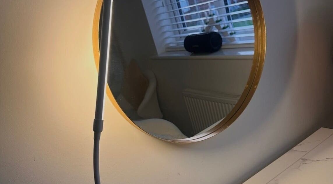 Stylish round mirror with gold rim at Caimem Hair, Swadlincote, England, GB enhancing chic interior design.