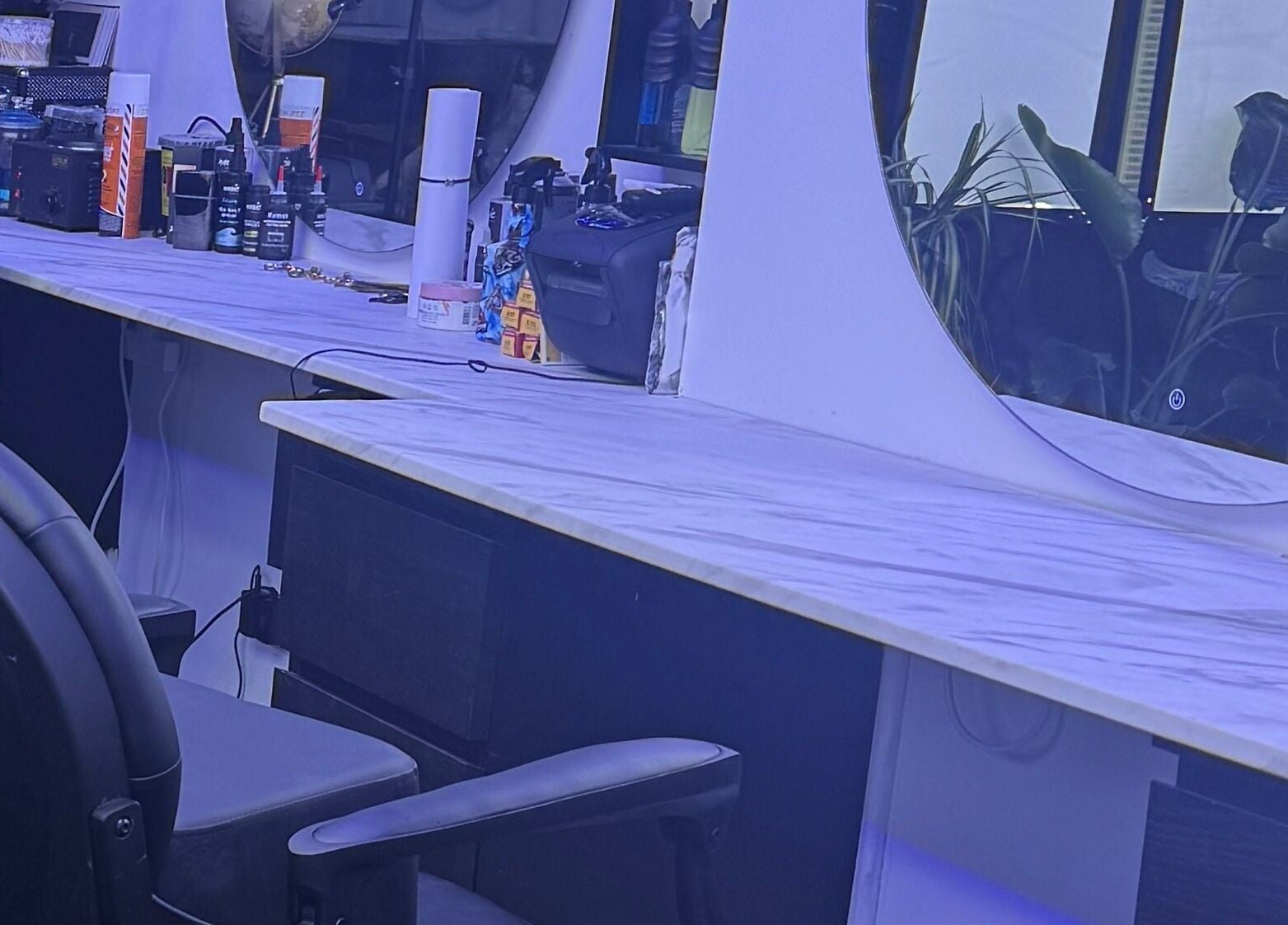 HE & SHE unisex salon, Bournemouth, England, GB showcases a stylish vanity with elegant mirrors and beauty products.