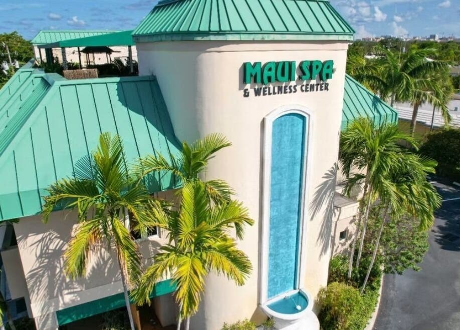 Elegant exterior view of Cryo Sculpting Lab - Boca in Boca Raton, Florida, US, surrounded by lush palms.