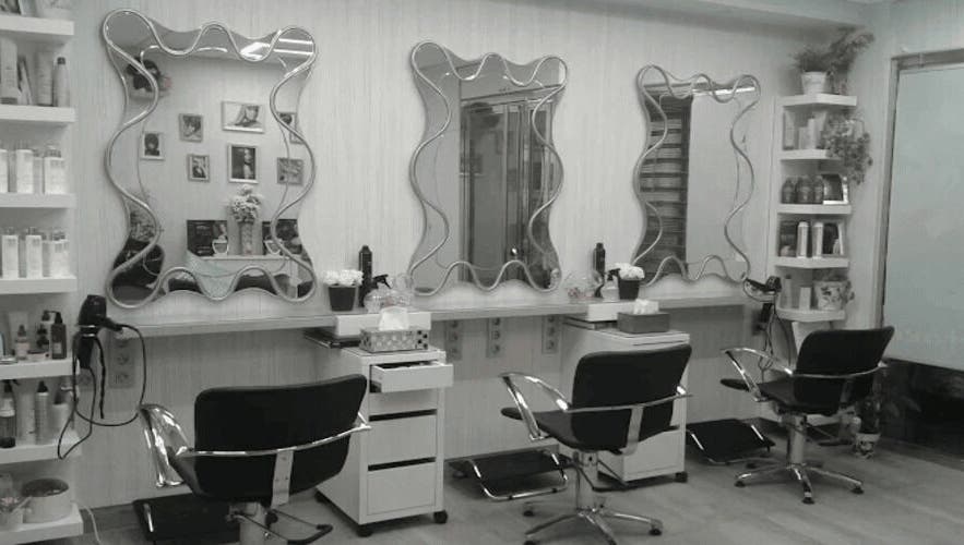 Interior moderno de Peluquería Marta en Málaga, Andalucía, ES, con espejos y sillas de estilo.