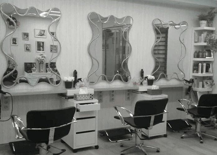 Interior moderno de Peluquería Marta en Málaga, Andalucía, ES, con espejos y sillas de estilo.