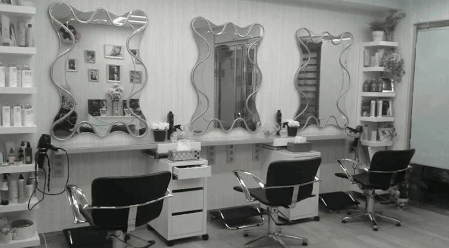 Interior moderno de Peluquería Marta en Málaga, Andalucía, ES, con espejos y sillas de estilo.