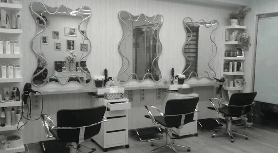 Interior moderno de Peluquería Marta en Málaga, Andalucía, ES, con espejos y sillas de estilo.