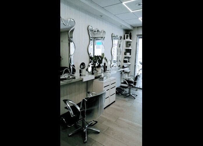 Interior de Peluquería Marta en Málaga, Andalucía, ES, con espejos ondulados y sillas modernas.