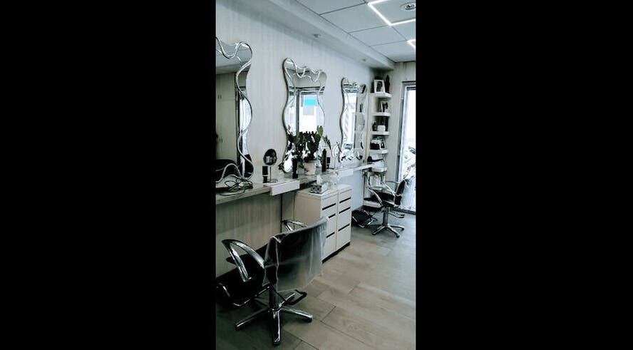 Interior de Peluquería Marta en Málaga, Andalucía, ES, con espejos ondulados y sillas modernas.