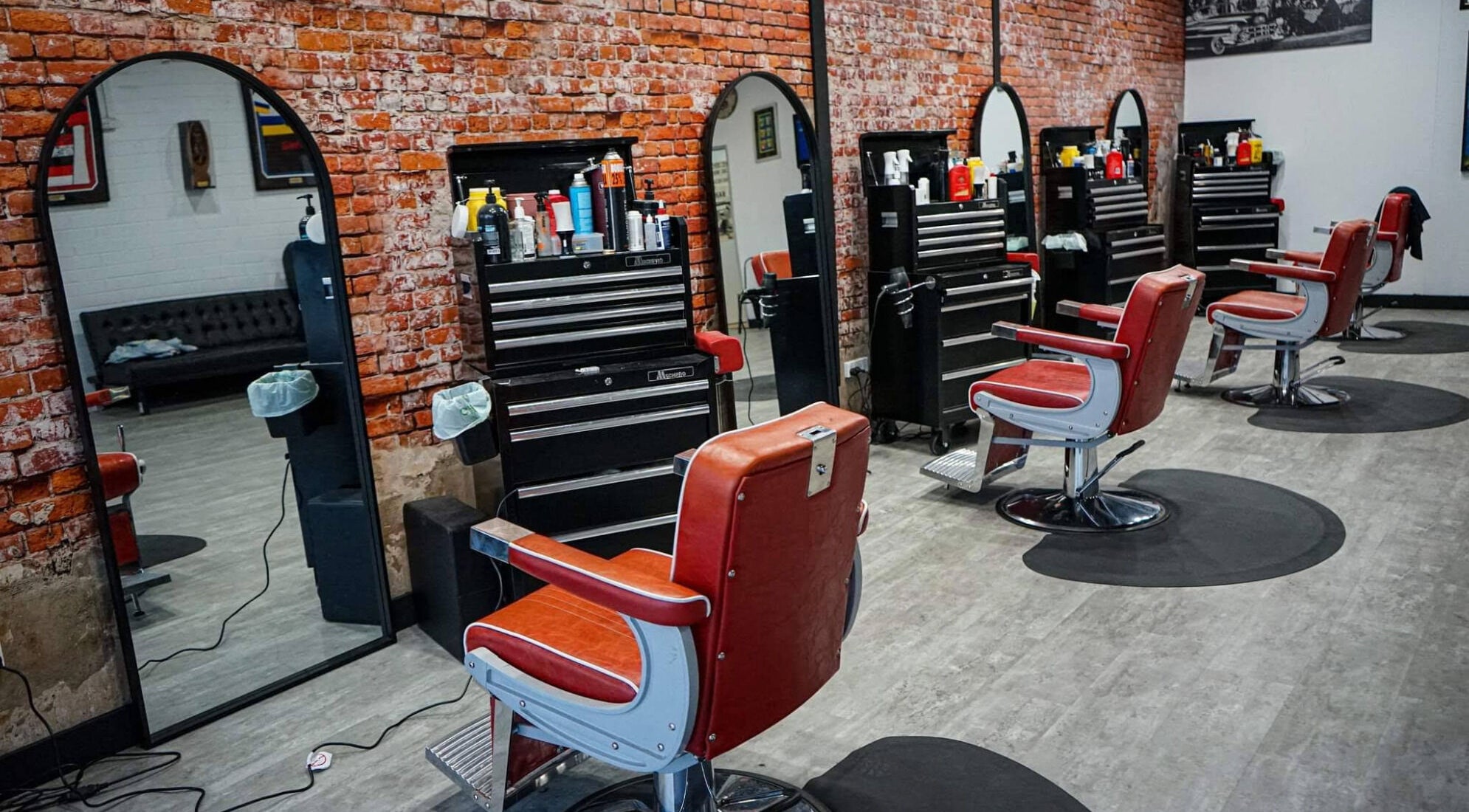 Inside The Elite Barbershop, Fyshwick, AU with vintage chairs and brick walls.