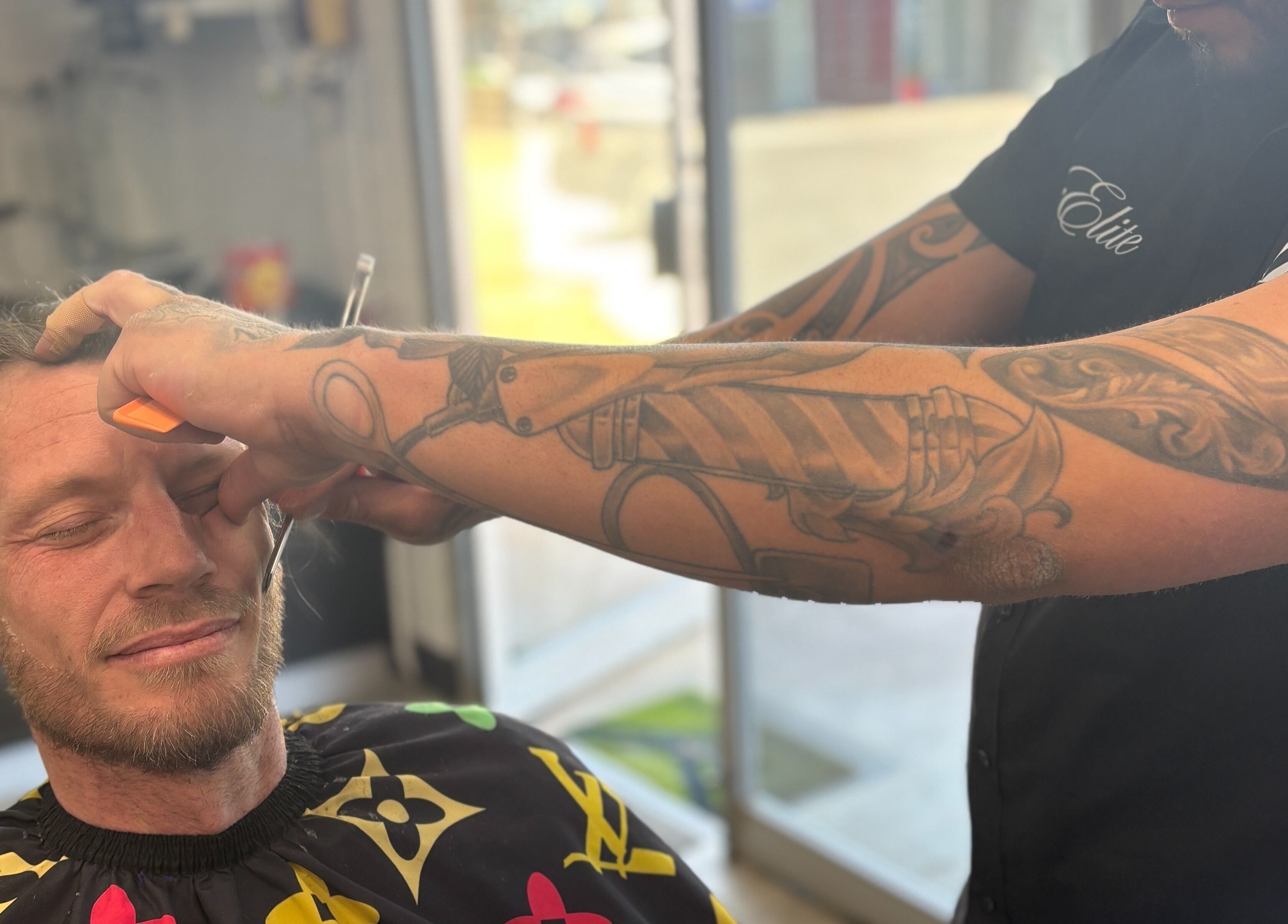 A client enjoys a precise haircut at The Elite Barbershop, Fyshwick, AU, highlighting expert barber skills.