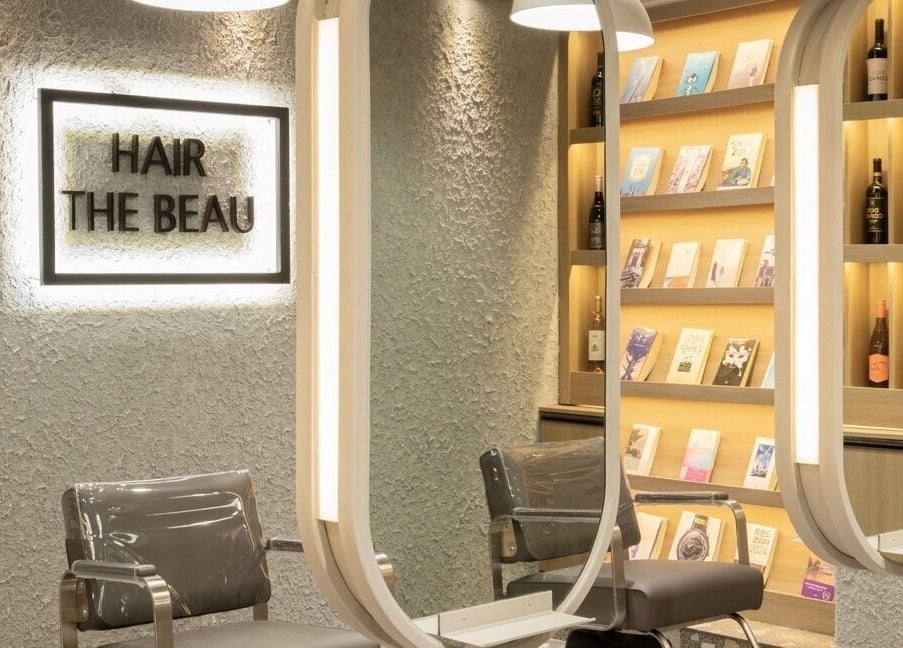 Elegant interior of Hair The Beau Nowon, 서울특별시, with stylish chairs and illuminated shelves.