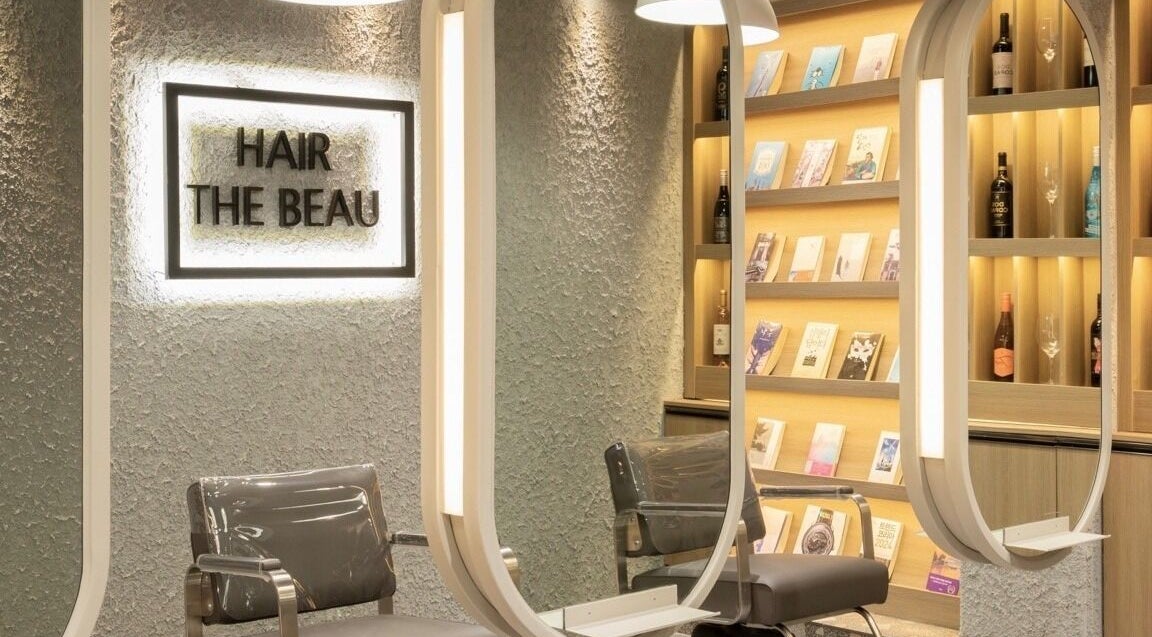 Elegant interior of Hair The Beau Nowon, 서울특별시, with stylish chairs and illuminated shelves.