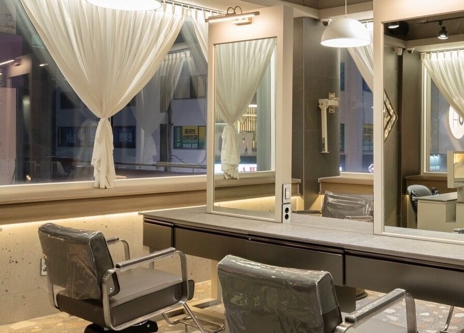 Modern hair styling area at Hair The Beau Nowon in 서울특별시, 서울특별시, KR with sleek chairs and mirrors.