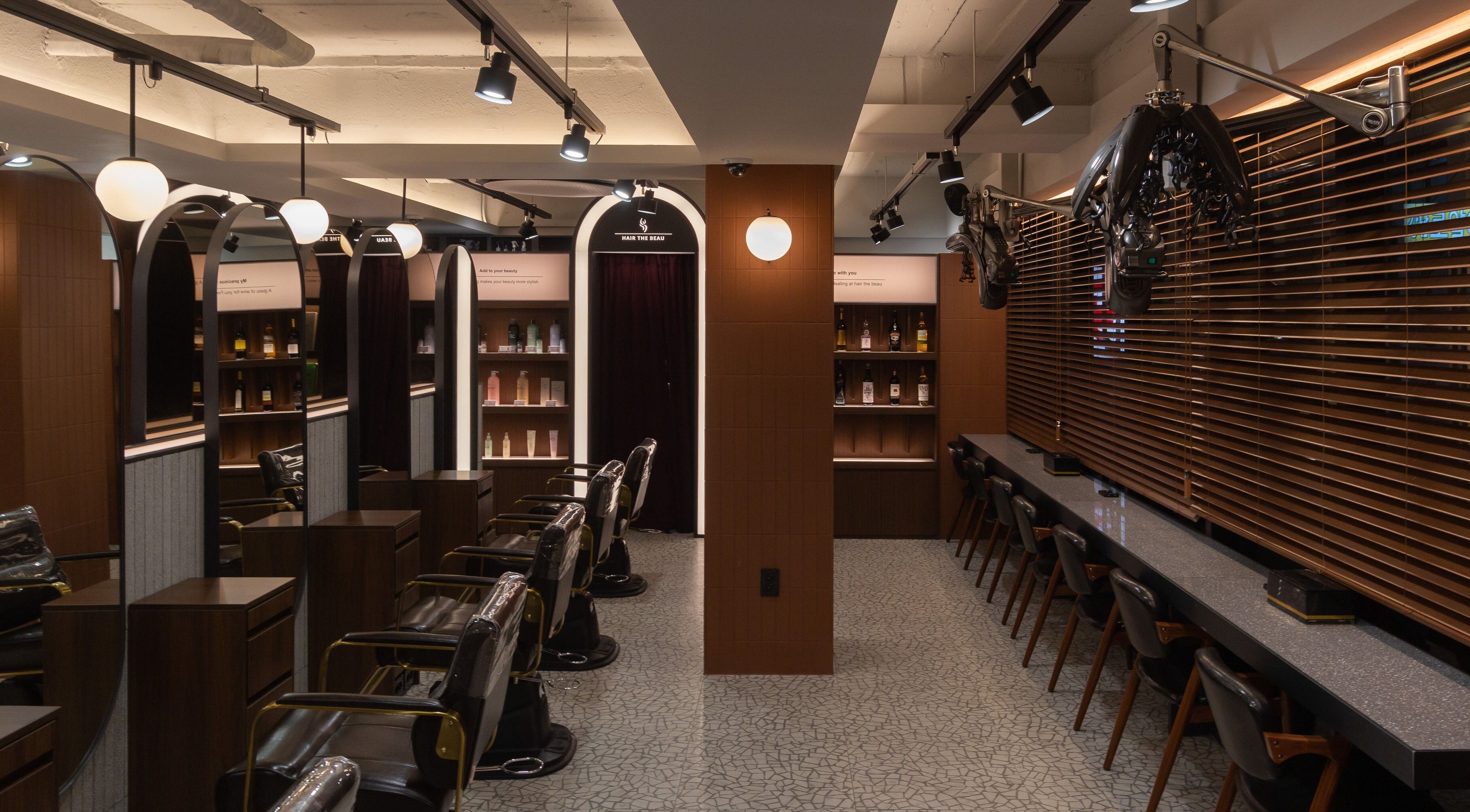 Modern salon interior at HAIR THE BEAU GANGNAM, 서울특별시, 서울특별시, KR, showcasing stylish chairs and decor.