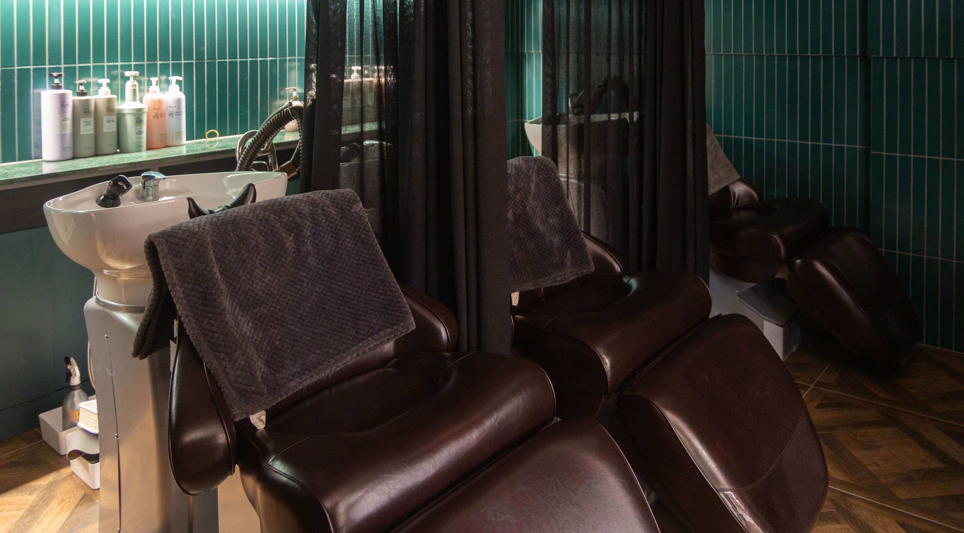Relaxing hair washing chairs at HAIR THE BEAU GANGNAM, 서울특별시, 서울특별시, KR with green tiled walls.