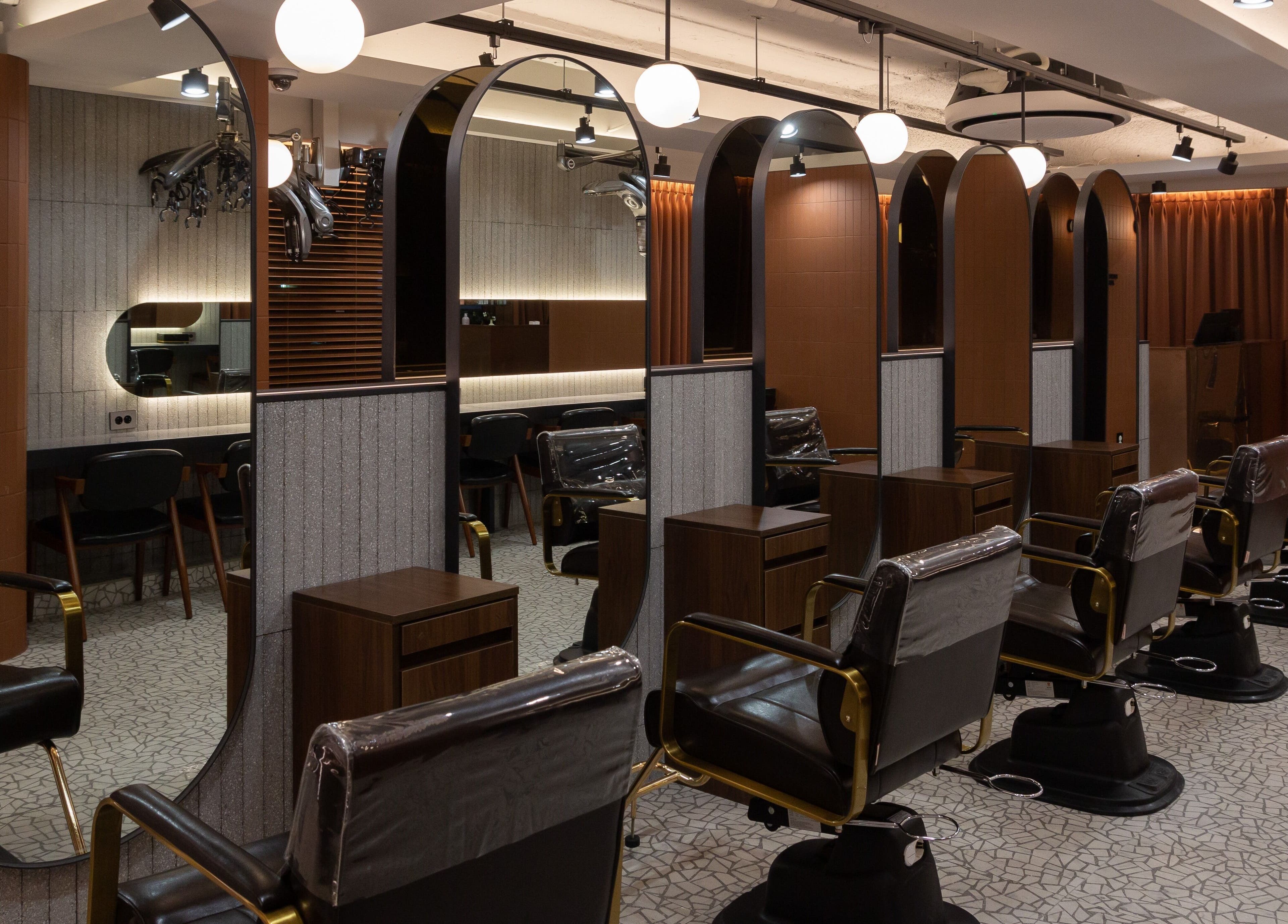 Elegant salon interior at HAIR THE BEAU GANGNAM, 서울특별시. Stylish chairs and mirrors enhance the beauty experience.