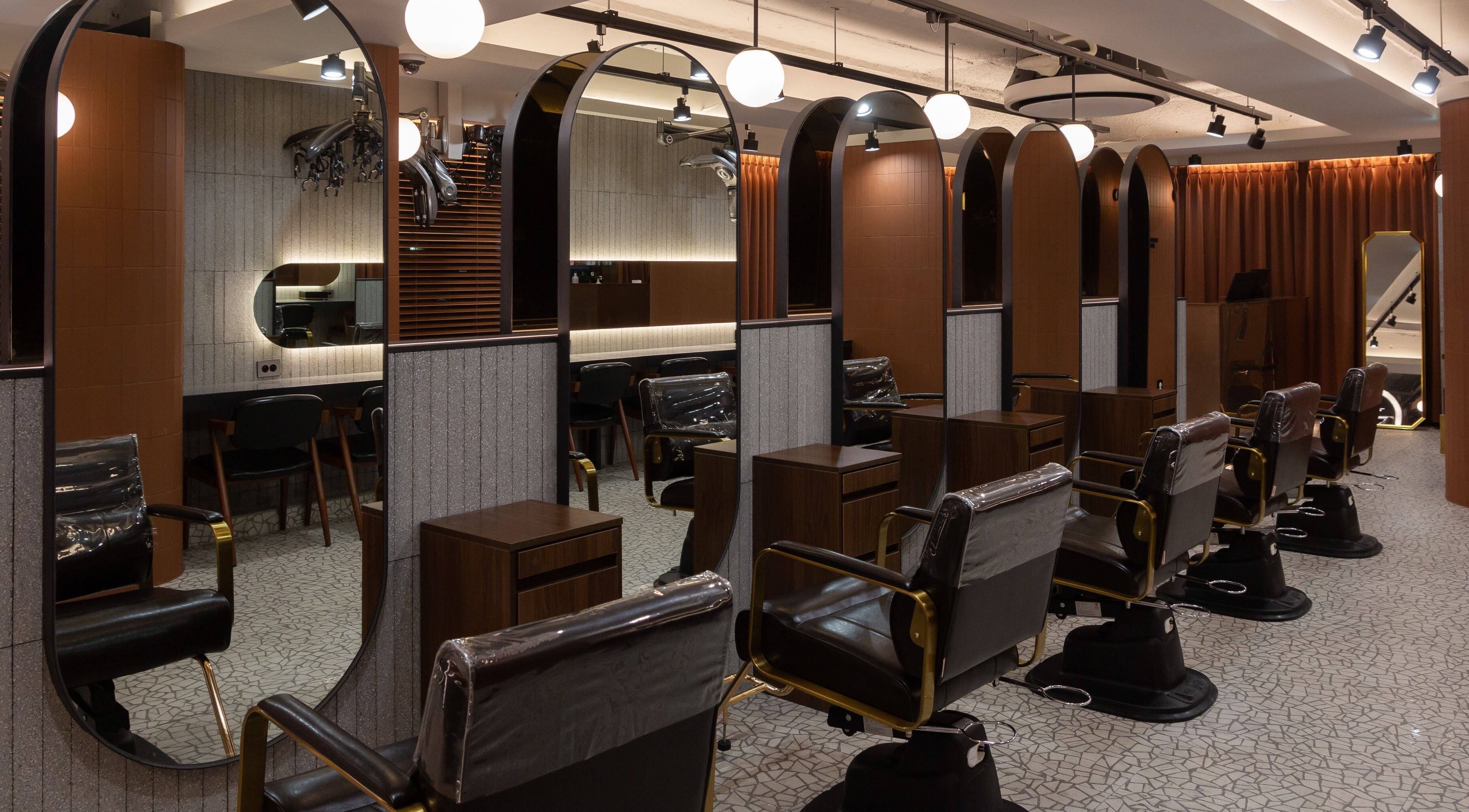 Elegant salon interior at HAIR THE BEAU GANGNAM, 서울특별시. Stylish chairs and mirrors enhance the beauty experience.
