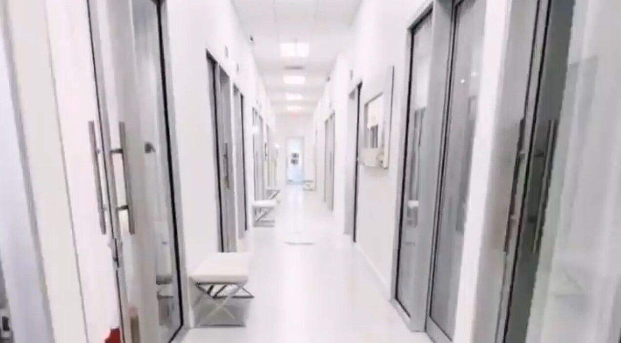 Modern corridor at LuxehairbyJo, Wellington, Florida, US, featuring elegant glass doors.