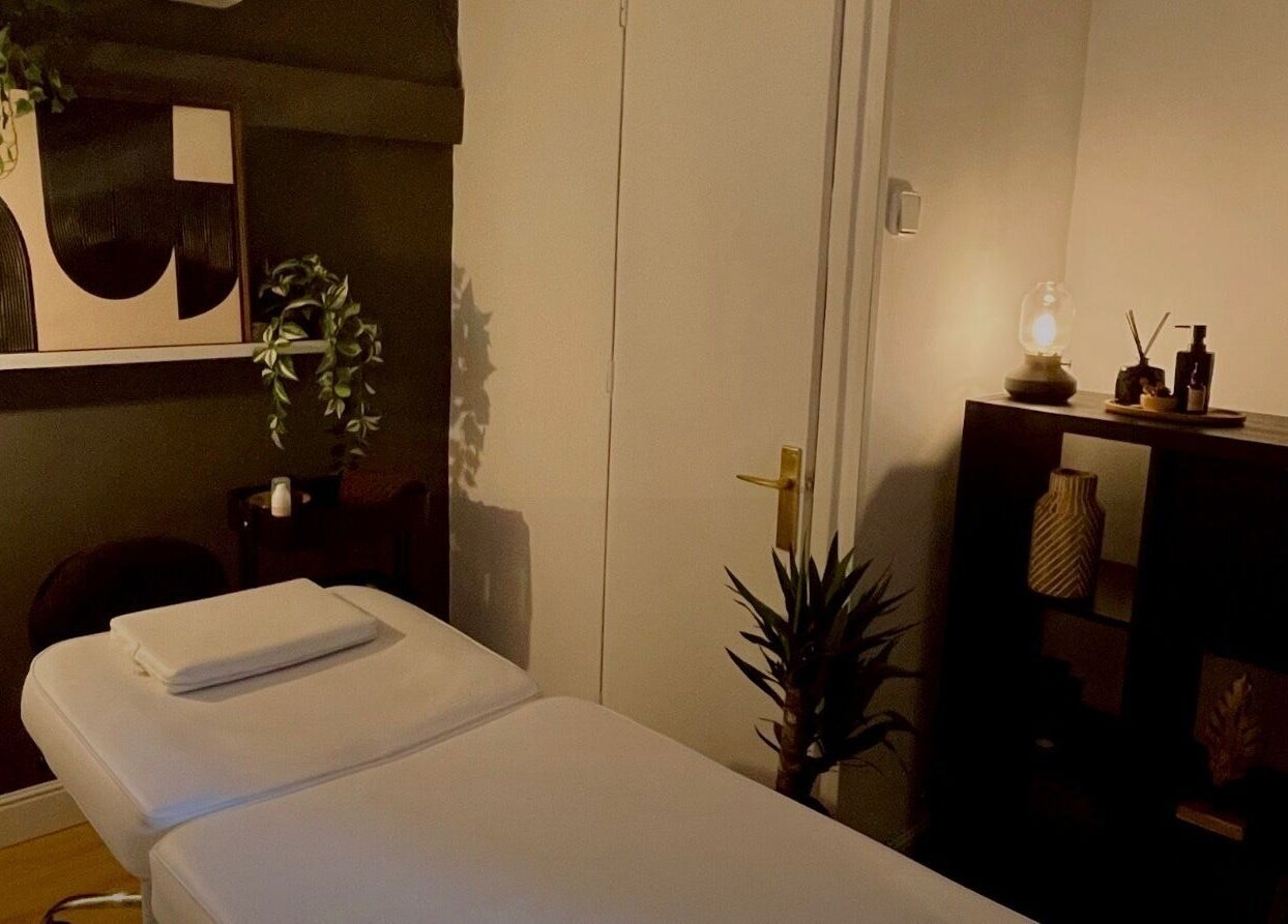 Sala de masajes acogedora en Respira HÛ en Bilbao, Euskadi, ES, con decoración elegante y plantas verdes.