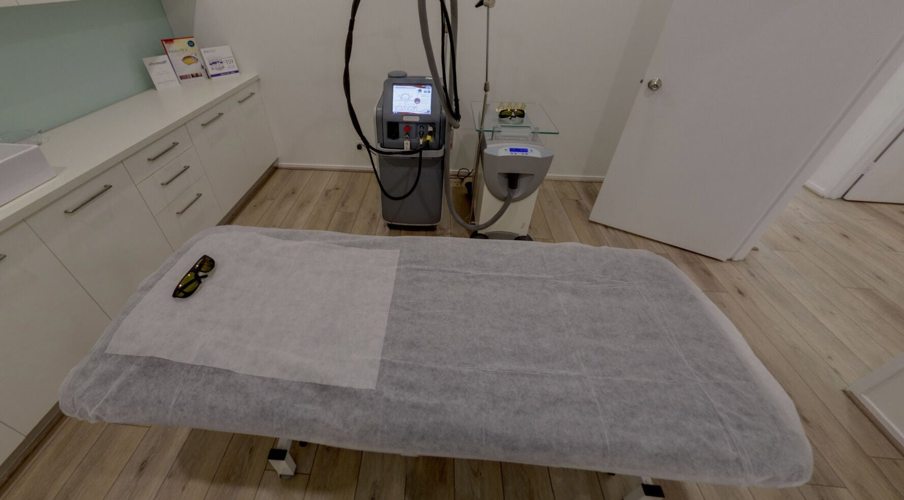 Treatment room at Skin and Laser Studio, St Leonards, New South Wales, AU, featuring a laser machine and bed.