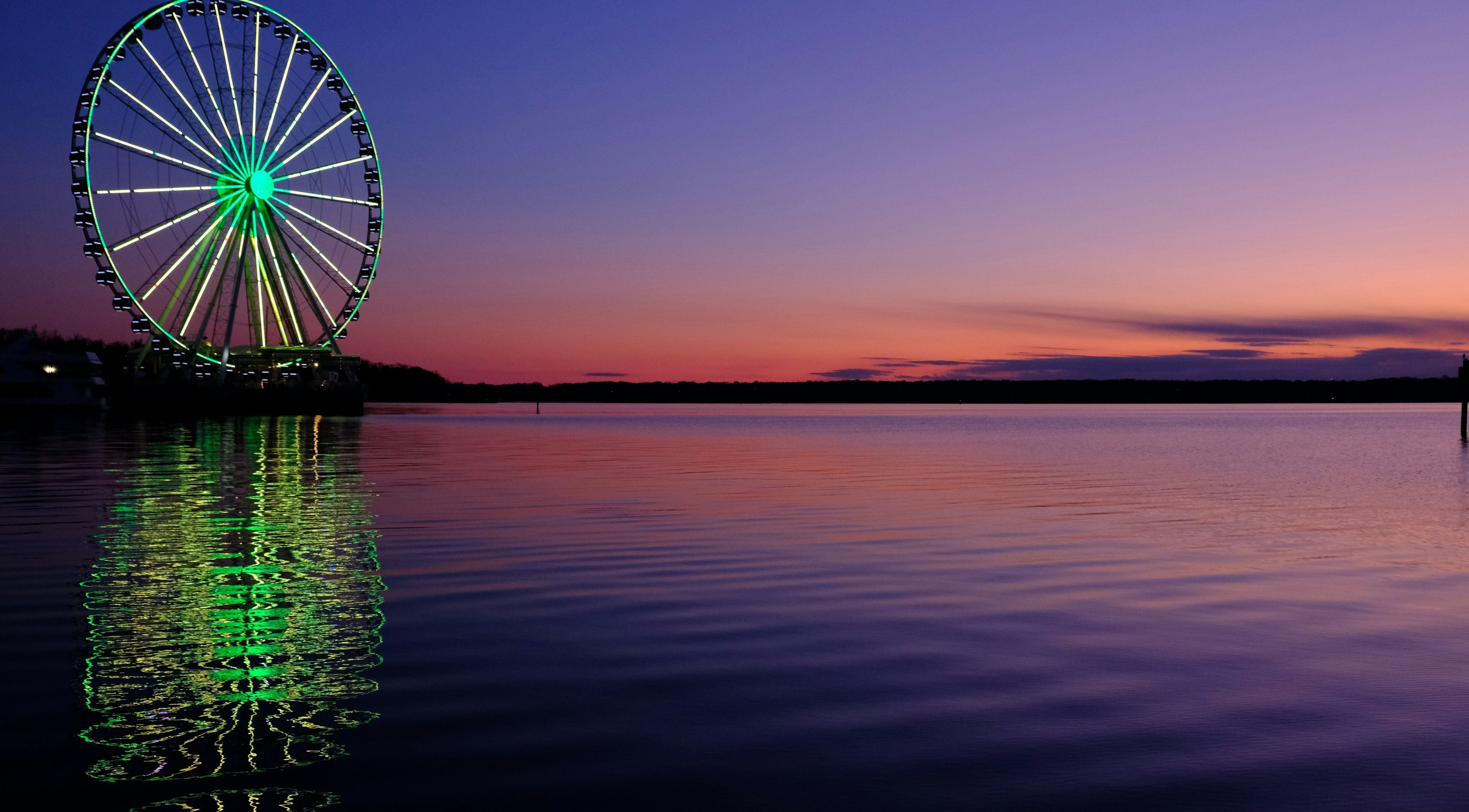 Night view of illuminated Ferris wheel near Le Forbici di Fede, Castello Di Cisterna, Campania, IT.