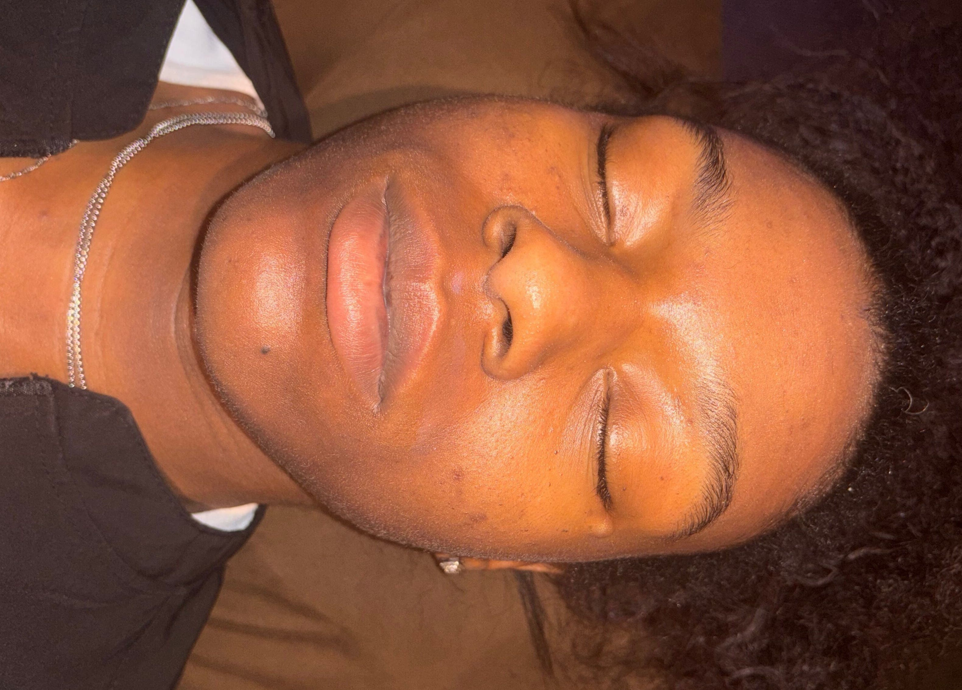 Client receiving facial treatment at iLondon Esthetics, Muskegon, Michigan, US, showcasing relaxed serenity.