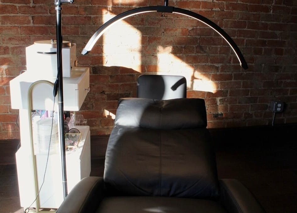Cozy treatment chair in Orbit Esthetics, Covington, Kentucky, US, bathed in natural sunlight.