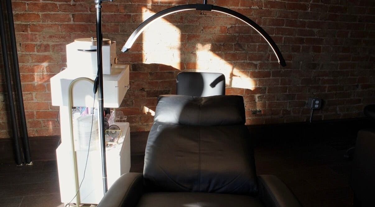 Relaxing esthetician chair at Orbit Esthetics in Covington, Kentucky, US with brick wall backdrop.
