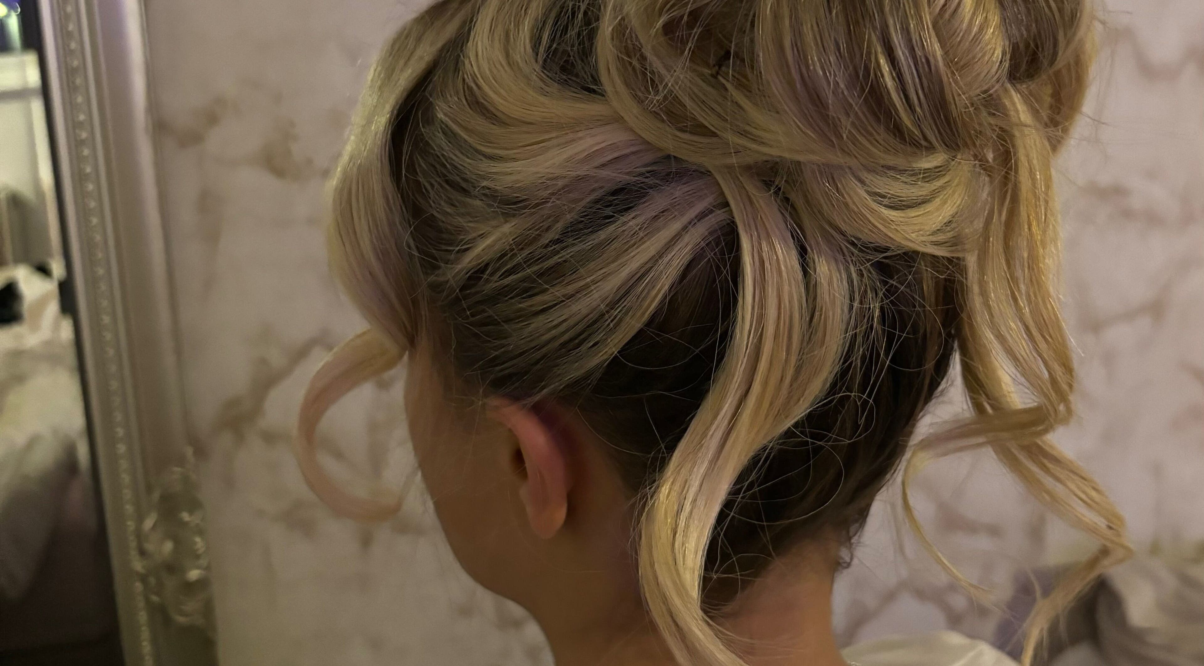 Elegant updo hairstyle at LM Blowdries, Bettws, Wales, GB showcasing blonde curls and style.
