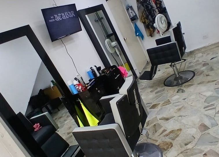 Interior moderno de Hc.barber en Cali, Valle Del Cauca, CO con sillas elegantes y espejo grande.