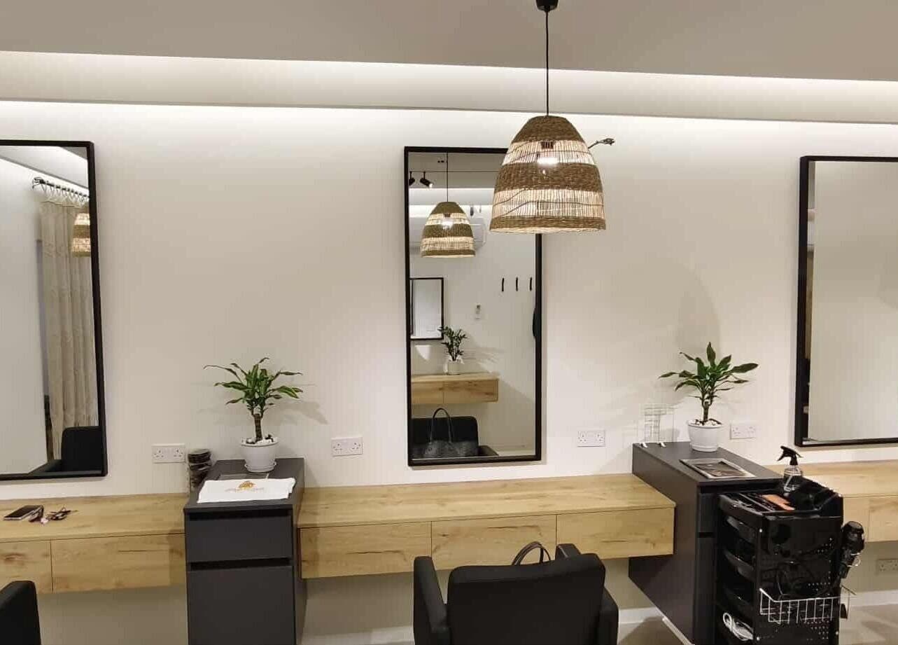 Modern salon interior at Sisters Retreat Salon and Spa in Doha, Doha Municipality, QA with sleek mirrors and plants.