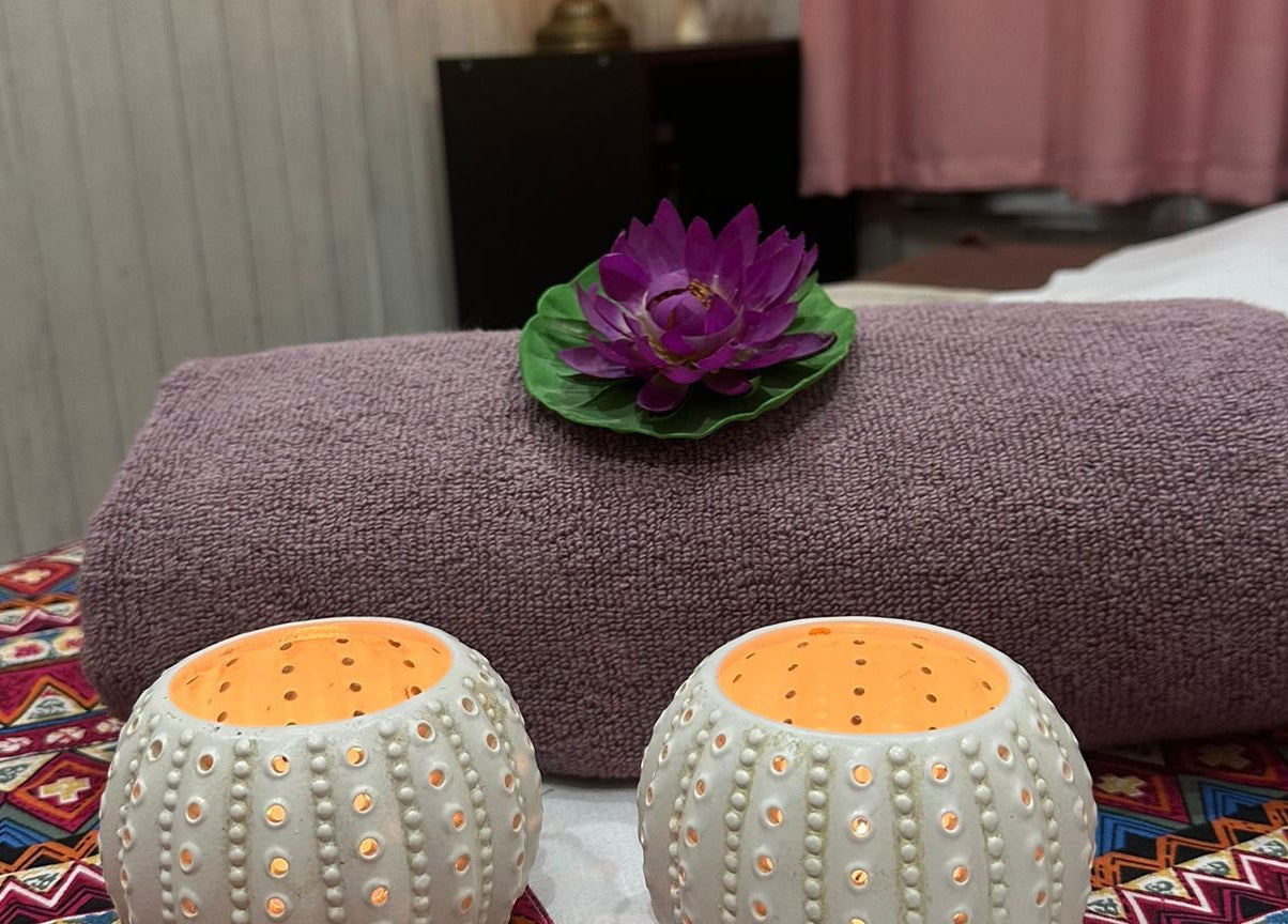 Tranquil setup at Nisa Thai Spa near Buckingham Palace, London. Purple towel and lotus detail.