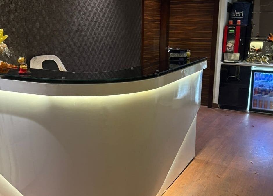 Reception area at Glamour Wellness Spa, Bengaluru, Karnataka, IN with a sleek counter and floral decor.
