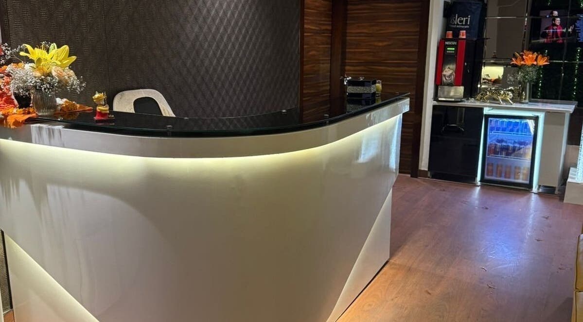 Reception area at Glamour Wellness Spa, Bengaluru, Karnataka, IN with a sleek counter and floral decor.