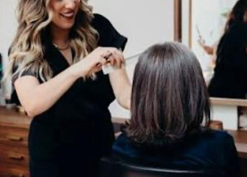 Stylist at KESALZ LLC in San Jose, California, US providing a professional haircut with a smile.