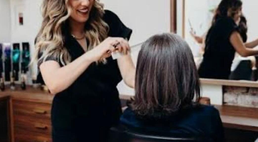 Stylist at KESALZ LLC in San Jose, California, US providing a professional haircut with a smile.