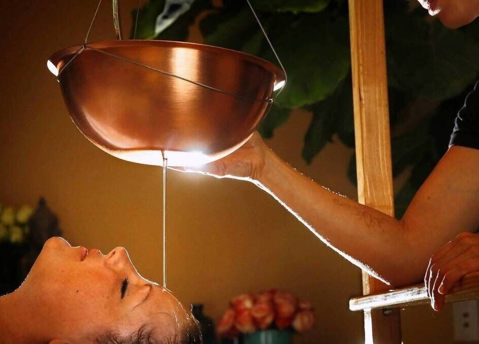 Ayurvedic therapy at KESALZ LLC in San Jose, California, US, showing a calming oil flow onto a client's forehead.