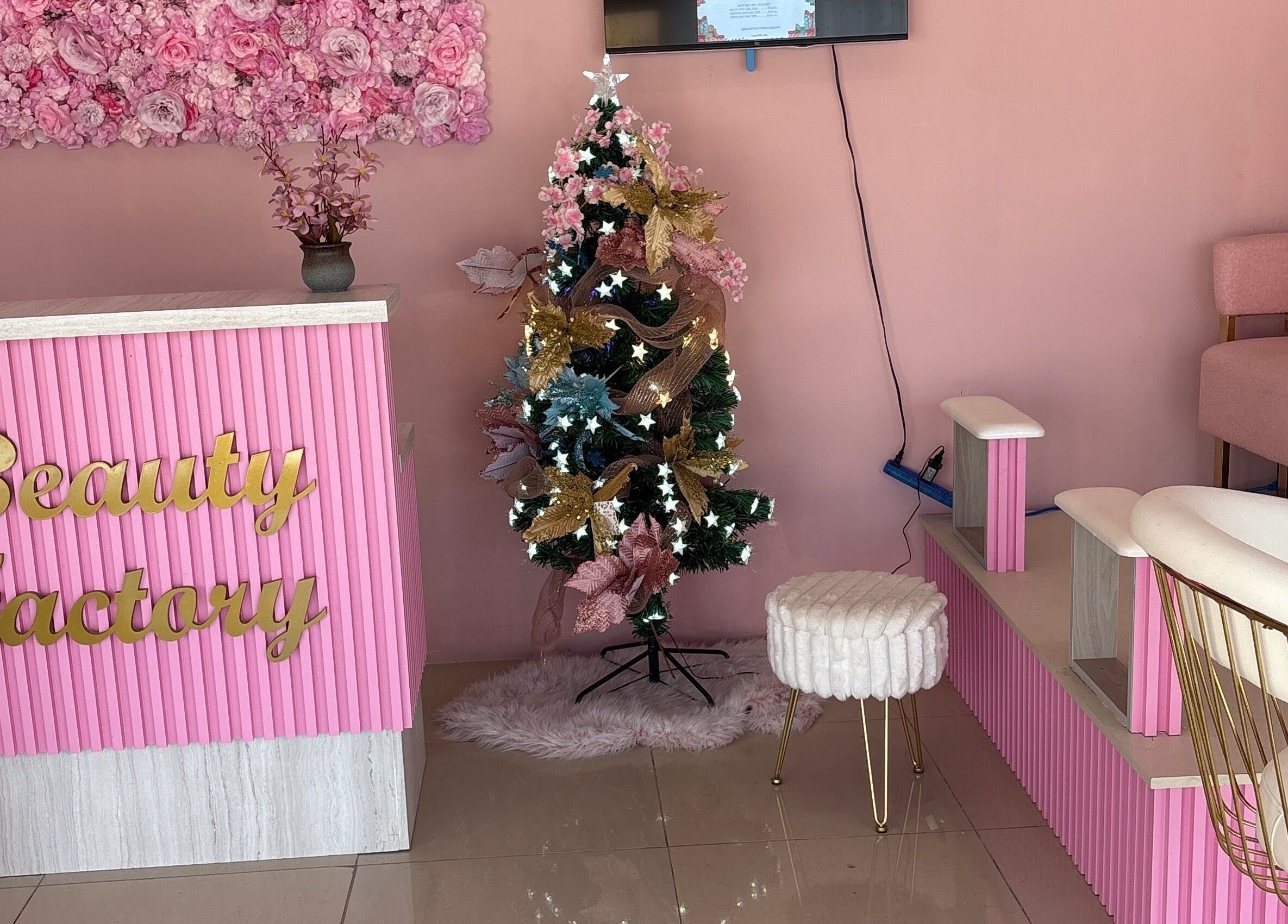 Interior del Beautyfactorycuracao en Willemstad, Curaçao, CW con decoración navideña y detalles florales rosados.