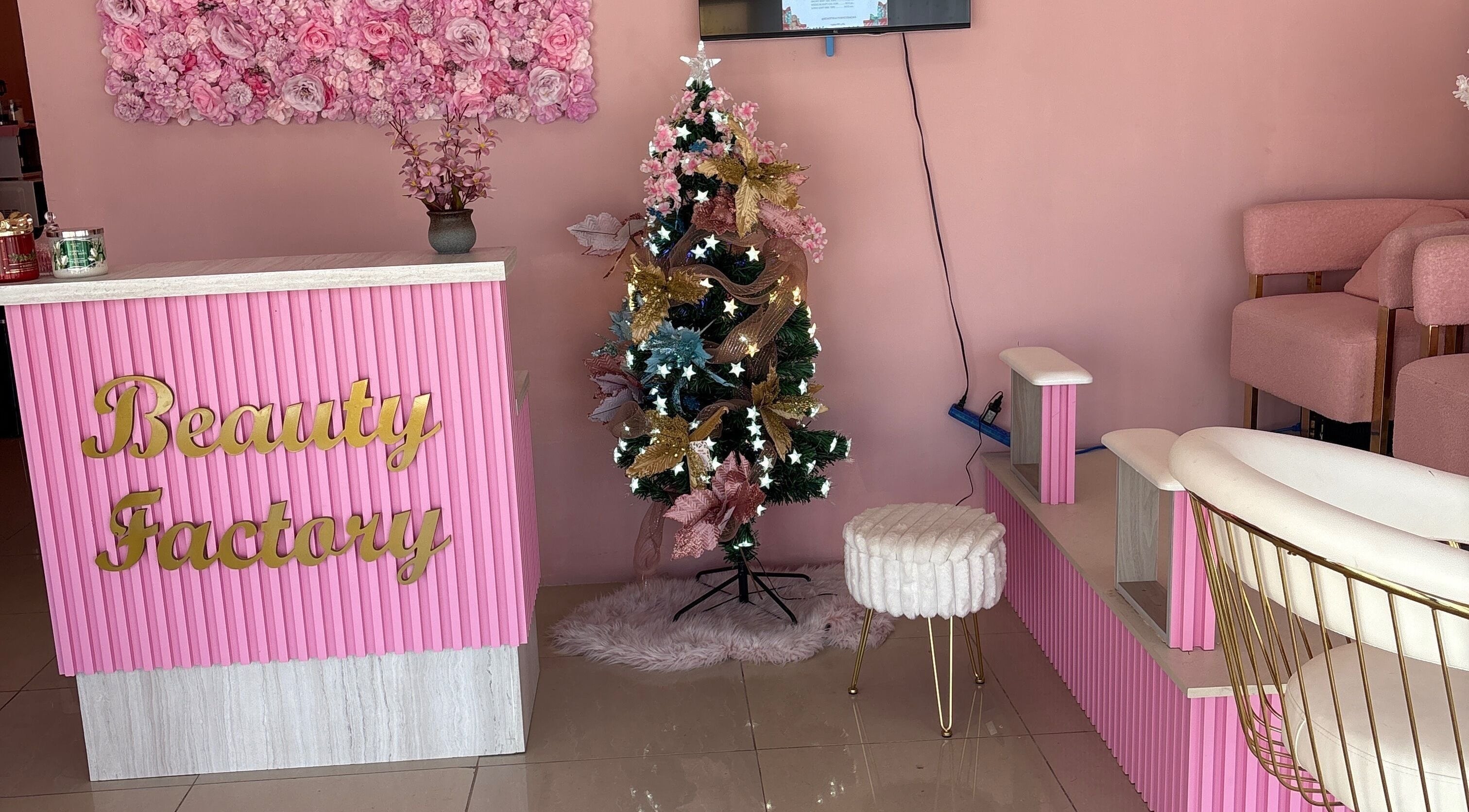Interior del Beautyfactorycuracao en Willemstad, Curaçao, CW con decoración navideña y detalles florales rosados.