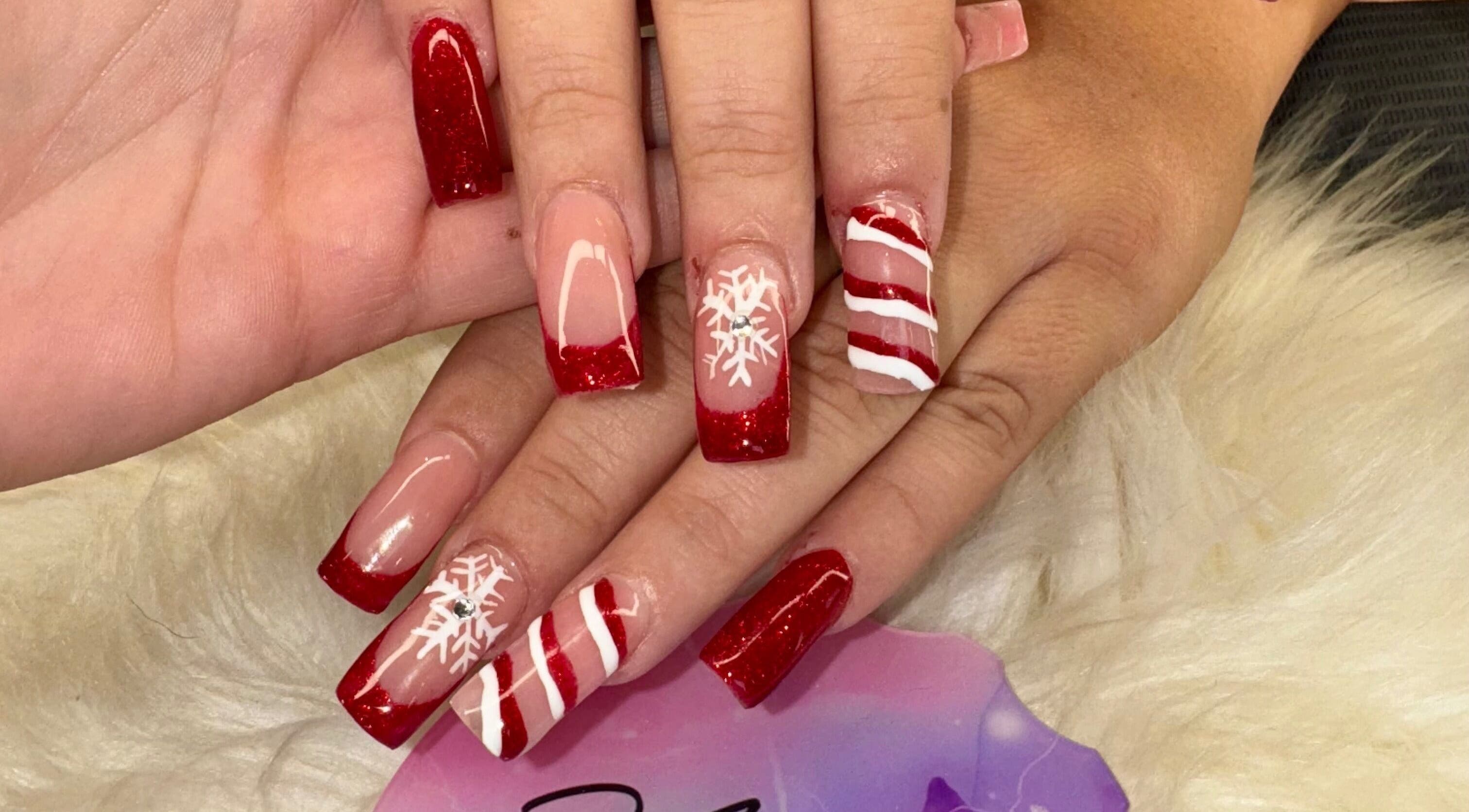 Festive red and white nail art at The Cass Effect in Deland, Florida, US, featuring intricate snowflake designs.