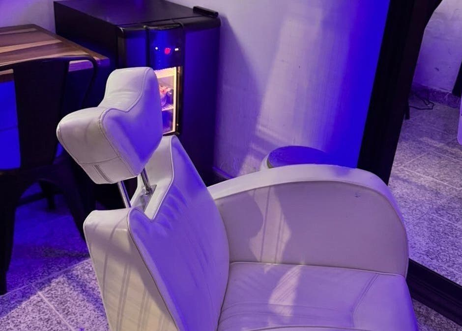 Espacio moderno en LA GUARIDA SPE, Buenos Aires, Buenos Aires, AR, con iluminación púrpura y silla blanca elegante.