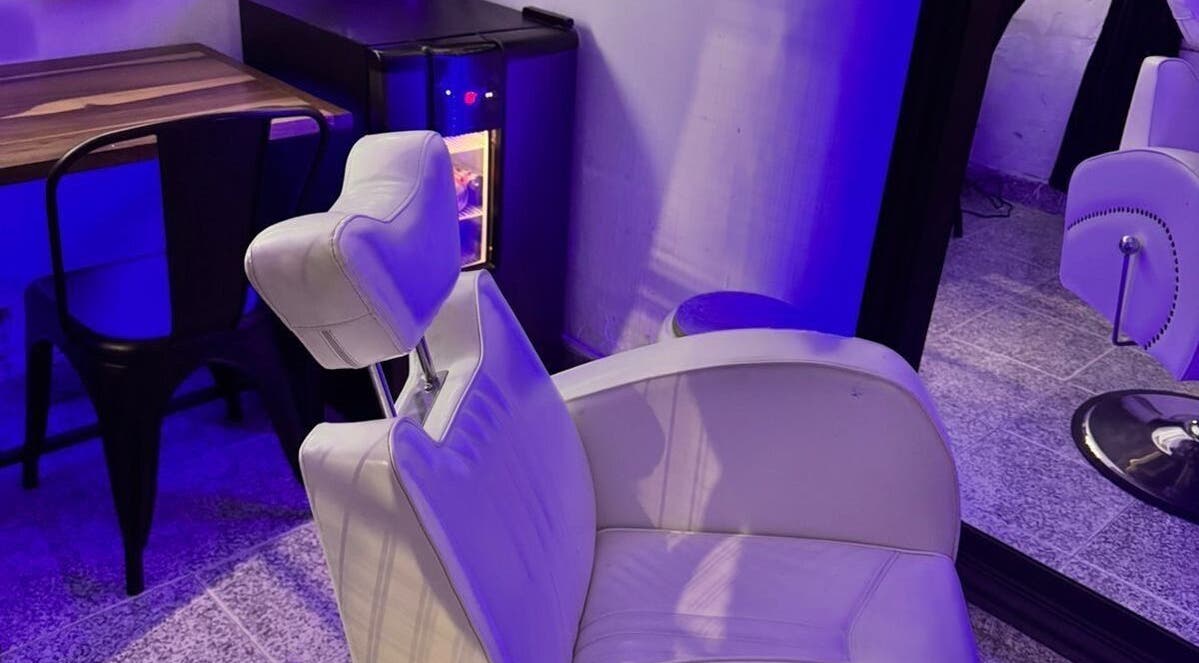 Espacio moderno en LA GUARIDA SPE, Buenos Aires, Buenos Aires, AR, con iluminación púrpura y silla blanca elegante.