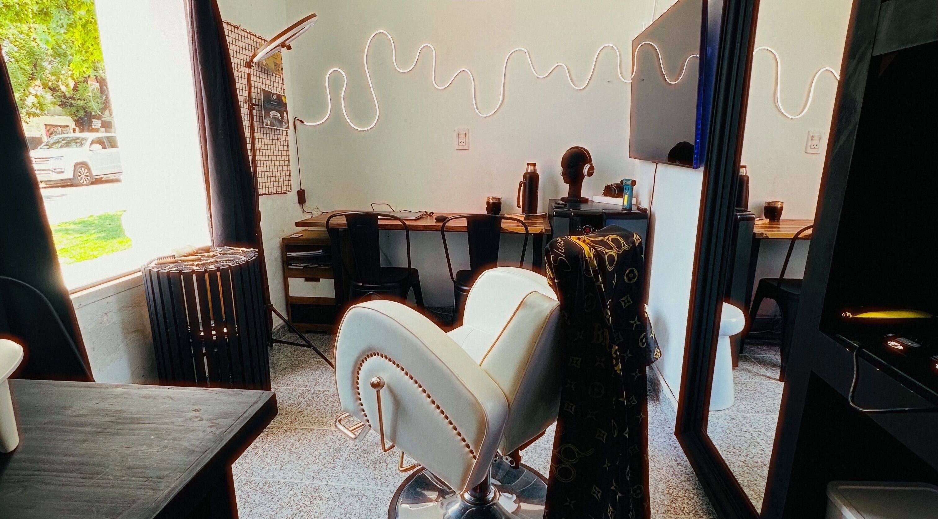 Interior moderno de LA GUARIDA SPE en Buenos Aires, con silla de peluquería y decoración acogedora.