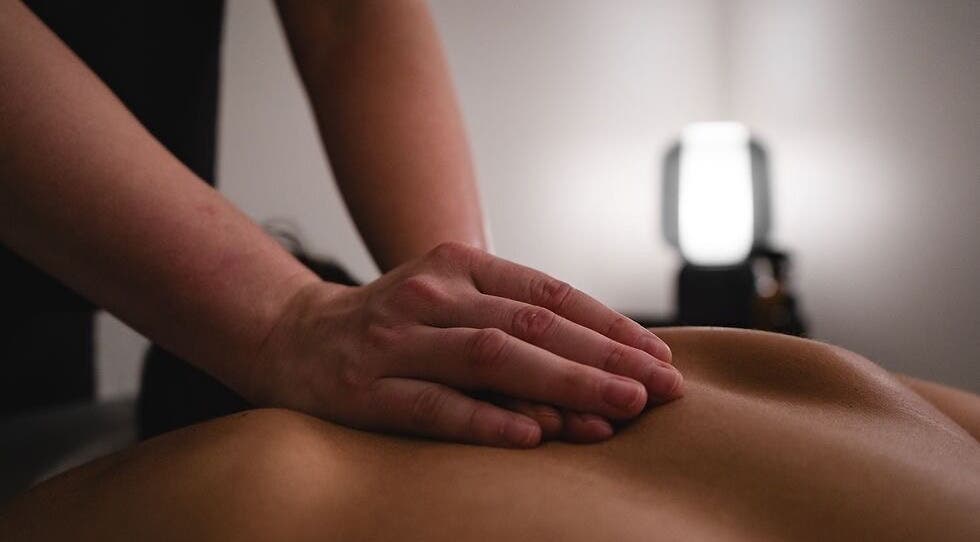 A soothing massage at Fitness Recovery and Massage in Leeds, England, GB. Close-up of a therapist's hands.