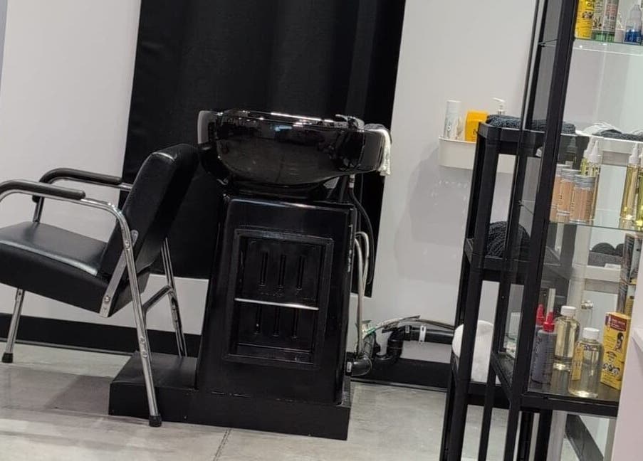 Station de lavage moderne chez Fashion By Nadia, Longueuil, Québec, CA, avec des produits de soins capillaires.