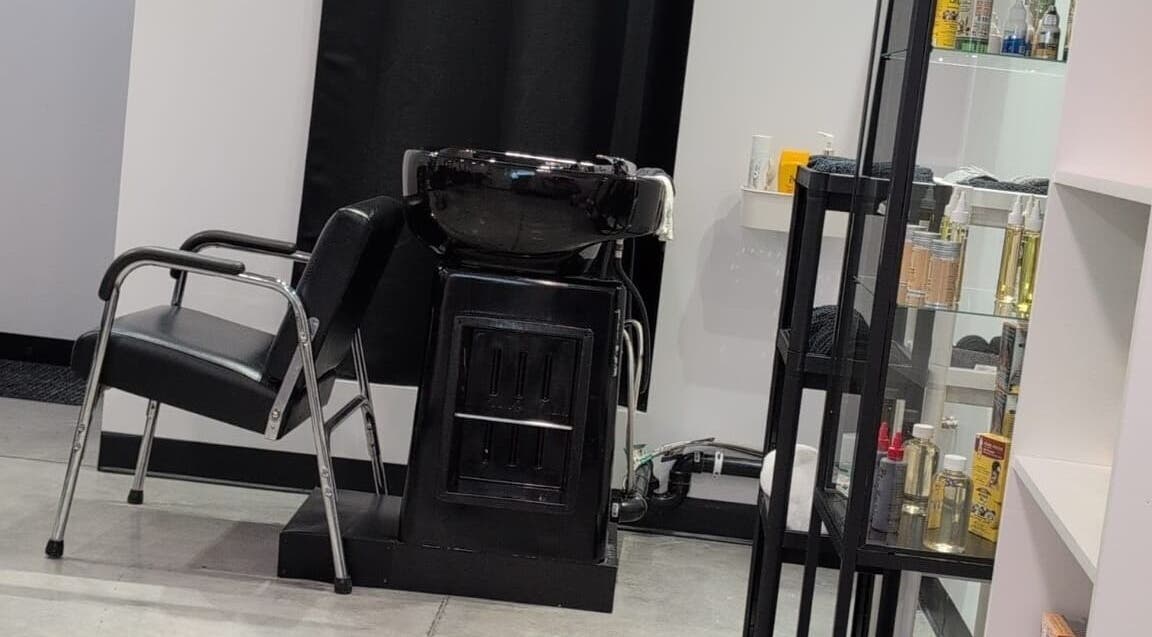 Station de lavage moderne chez Fashion By Nadia, Longueuil, Québec, CA, avec des produits de soins capillaires.