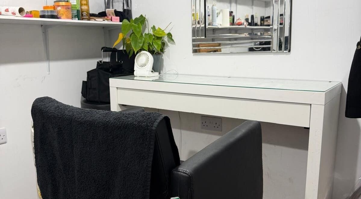A stylish workstation at Priceless Hair and Beauty, Slough, England, GB, with a chair, desk, and mirror.