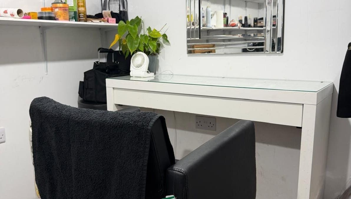 Styling station at Priceless Hair and Beauty, Slough, England, GB with black chair and plant decor.