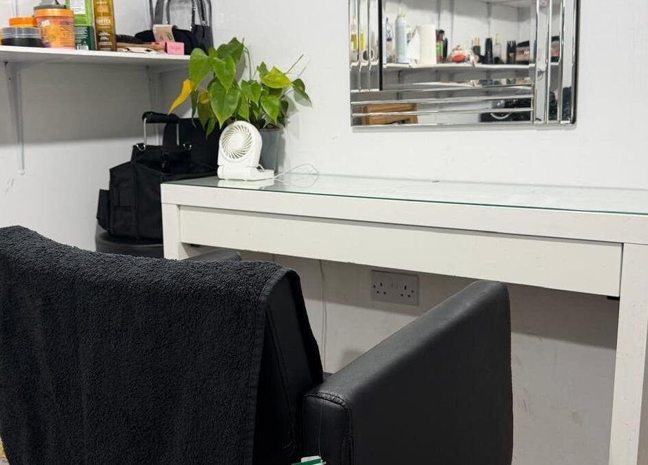 Styling station at Priceless Hair and Beauty, Slough, England, GB with black chair and plant decor.