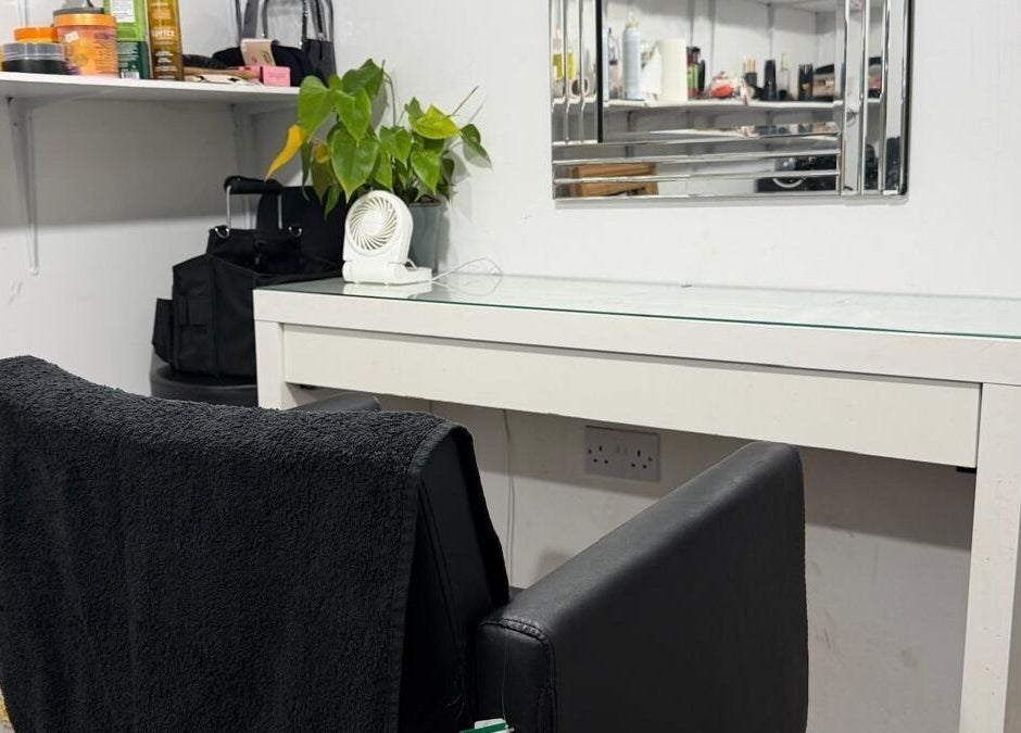 Styling station at Priceless Hair and Beauty, Slough, England, GB with black chair and plant decor.